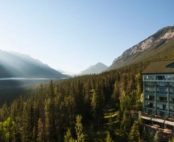 View from a hotel of sun-rays peaking over the mountain view onto the lake below.