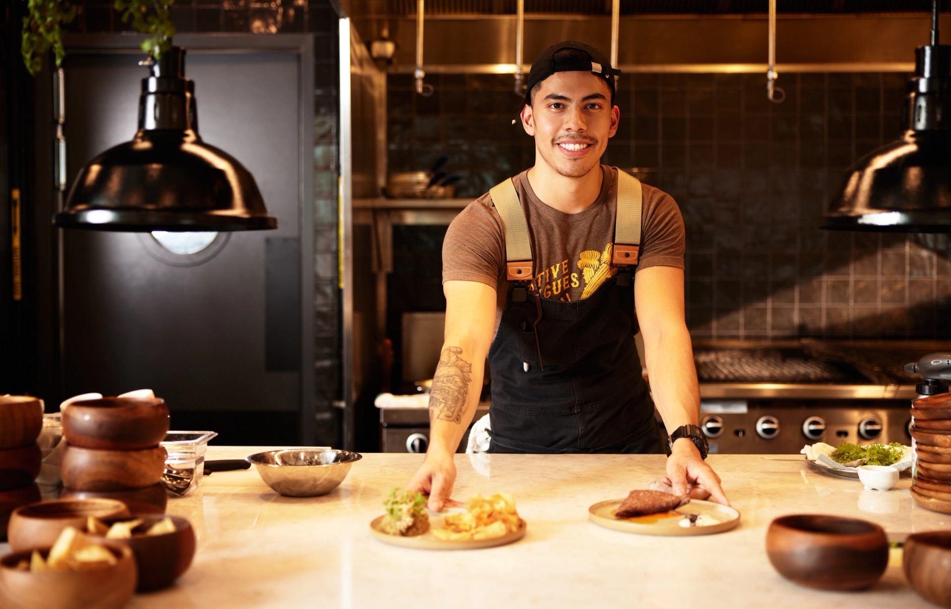 Smiling chef showing off his dishes in a contemporary kitchen