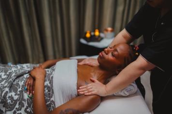 A woman relaxes on a massage table during a massage.