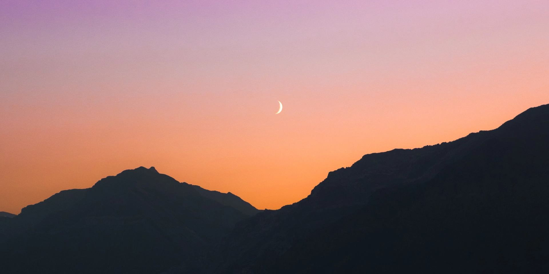 Moon above mountains at sunset
