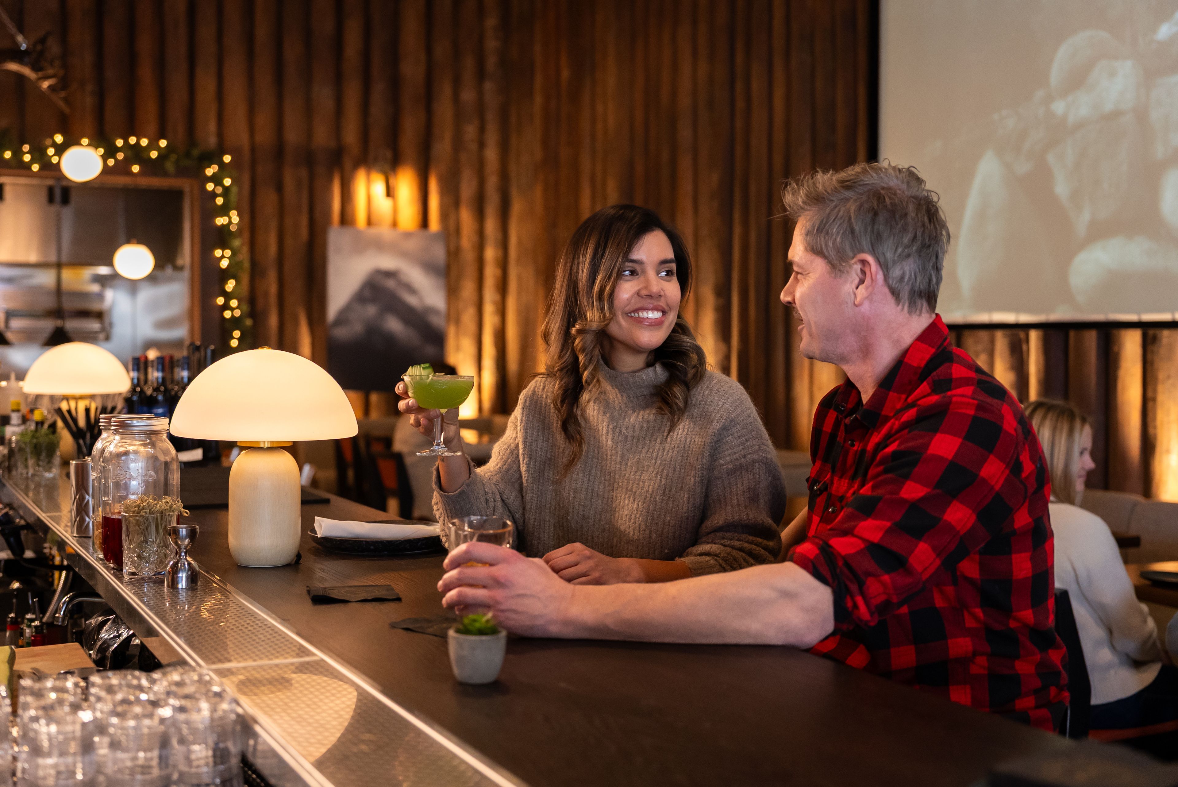 Couple sitting at bar with cocktails