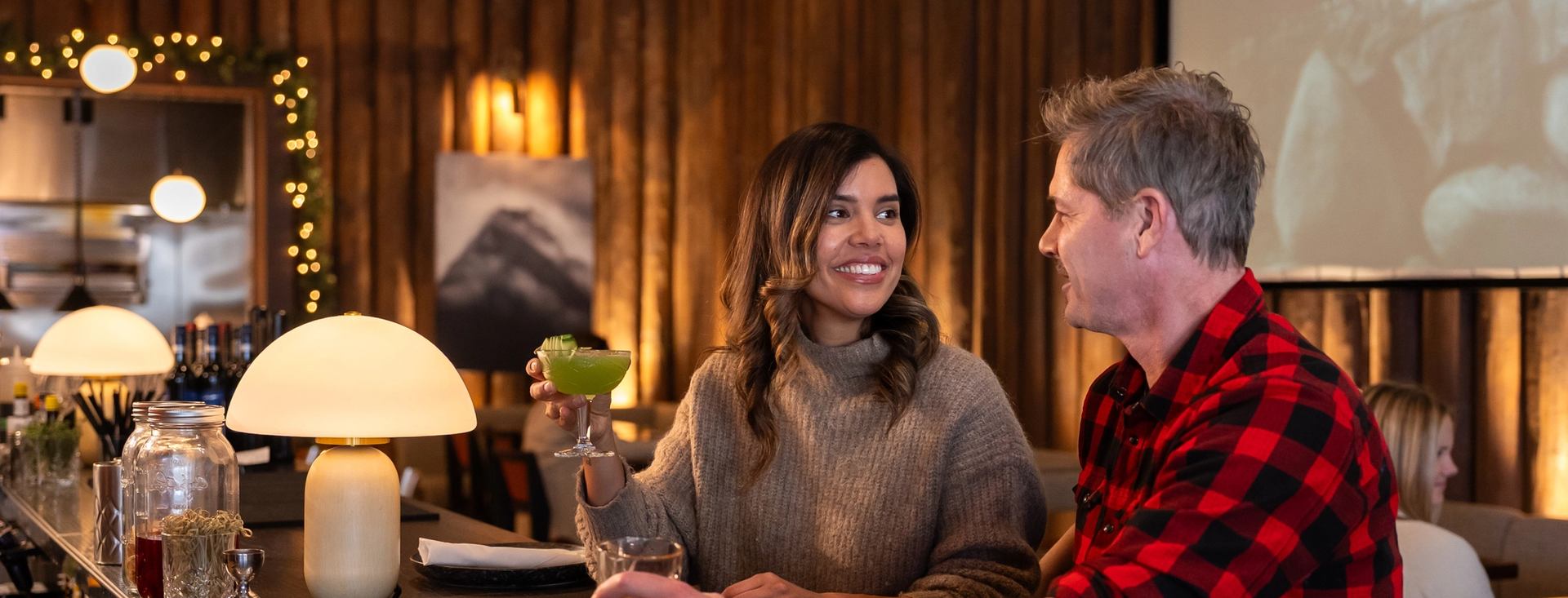 Couple sitting at bar with cocktails