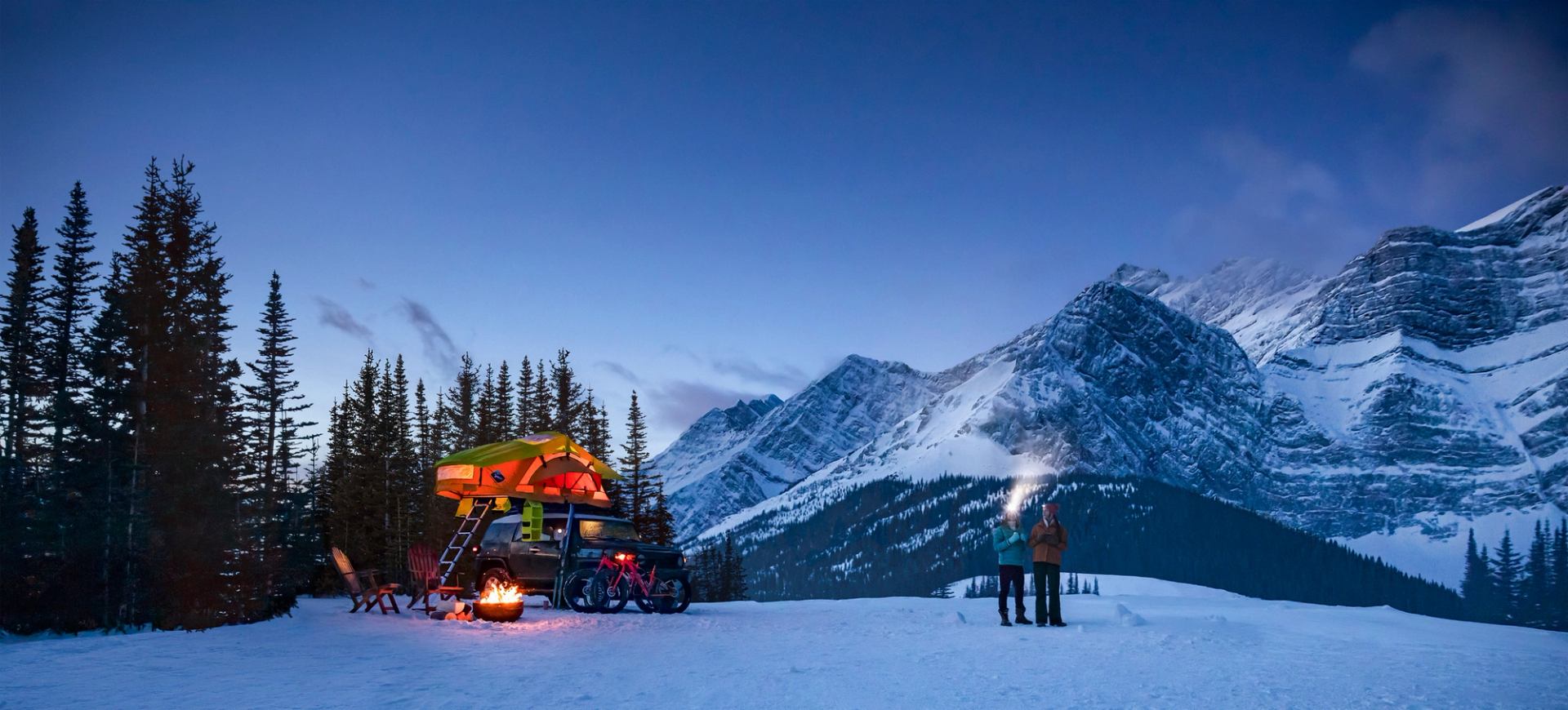 Couple winter camping at night at Fortress Mountain in Kananaskis Country.