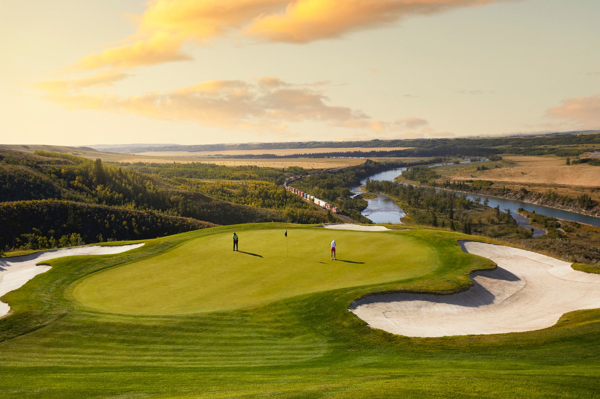 Scenic wide shot of people golfing at the 16th hole at Links of GlenEagles in Cochrane.