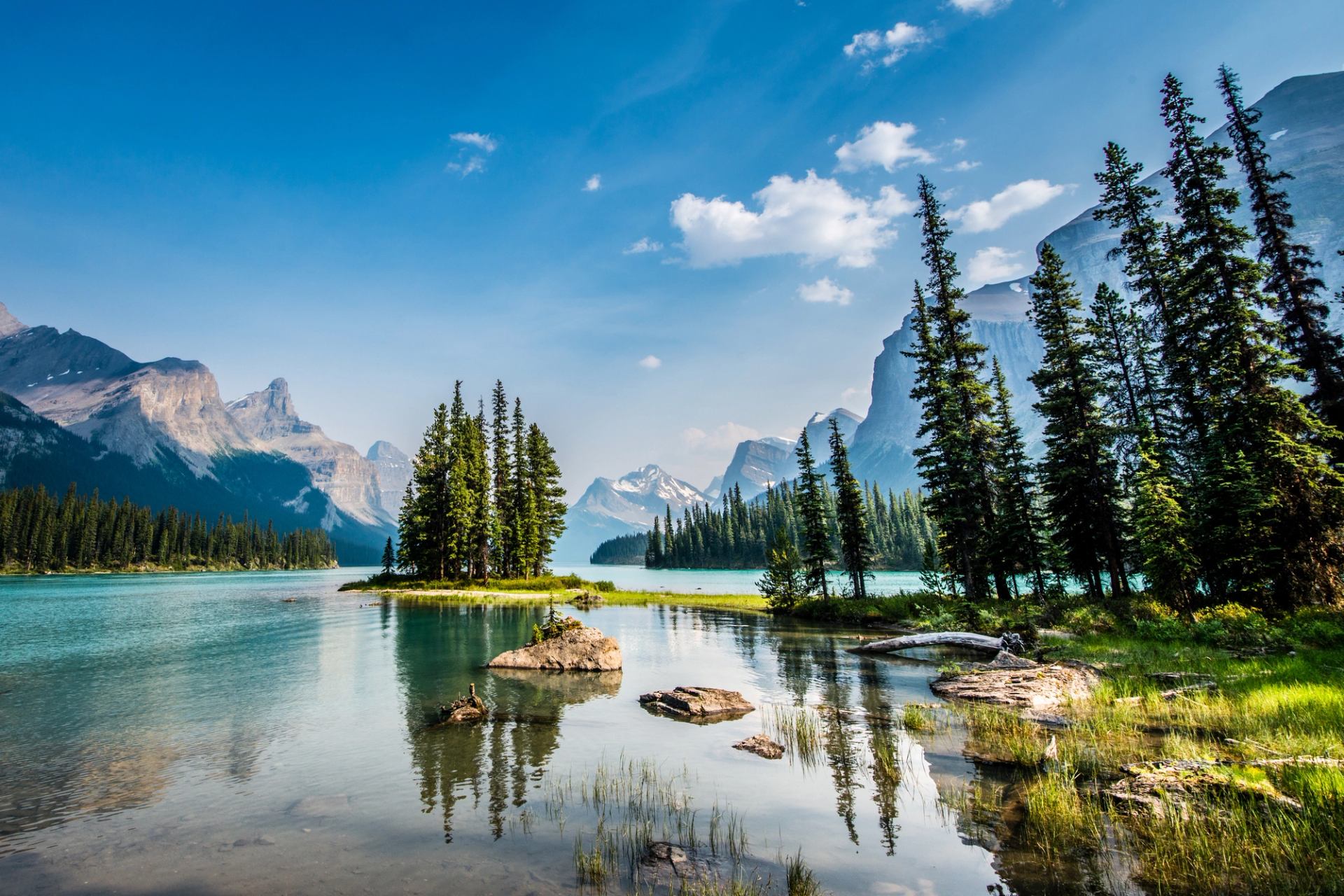 Scenic view of Spirit Island and trees reflecting in Maligne Lake in Jasper National Park.