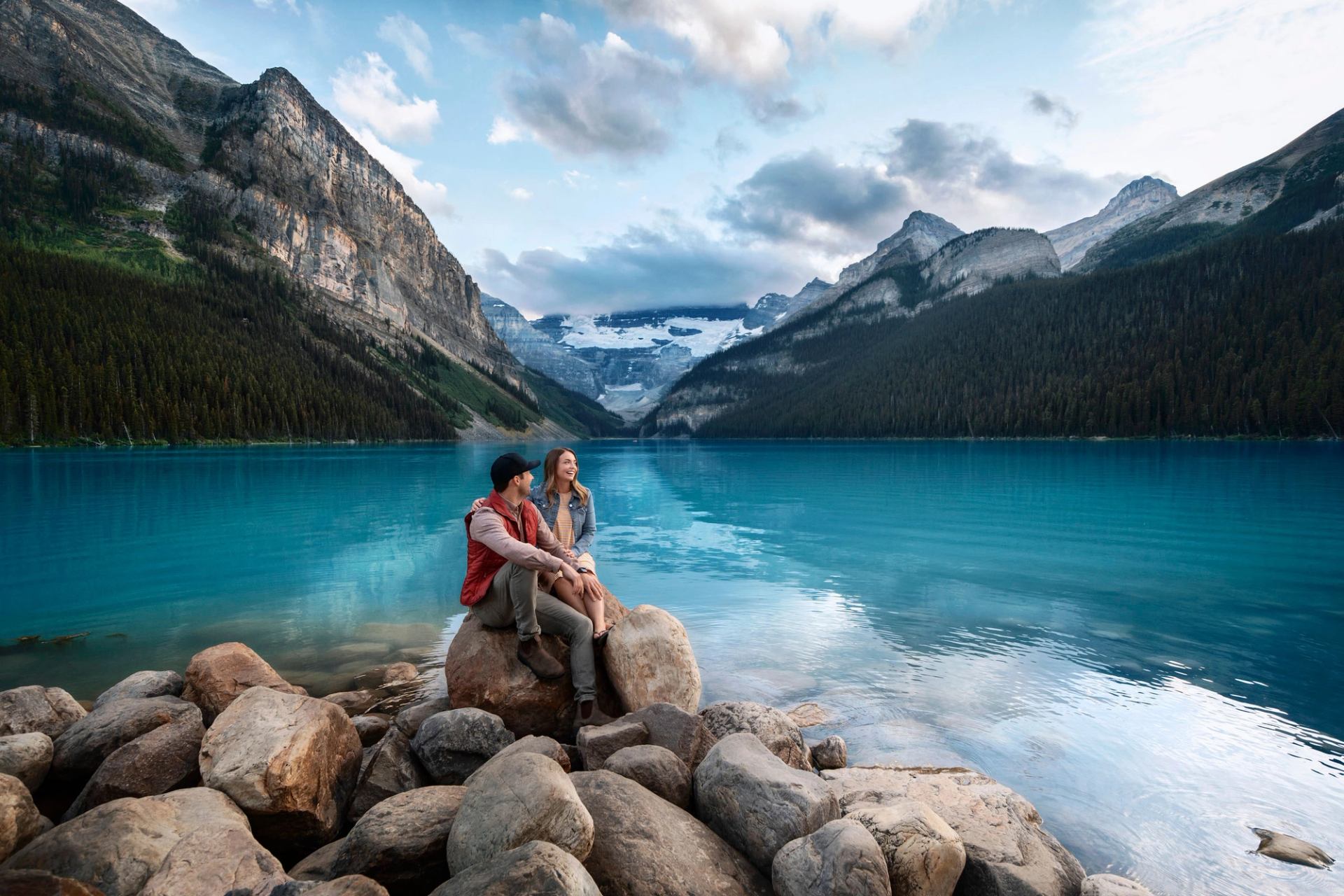 Two hikers enjoying the view at Lake Louise.