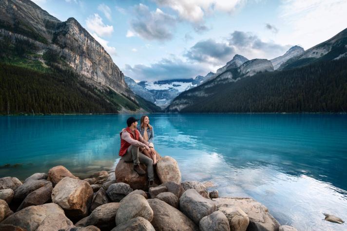 Two hikers enjoying the view at Lake Louise.