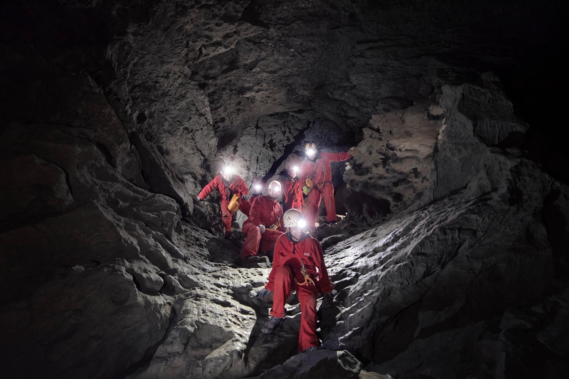 Group of people exploring a cave wearing headlamps