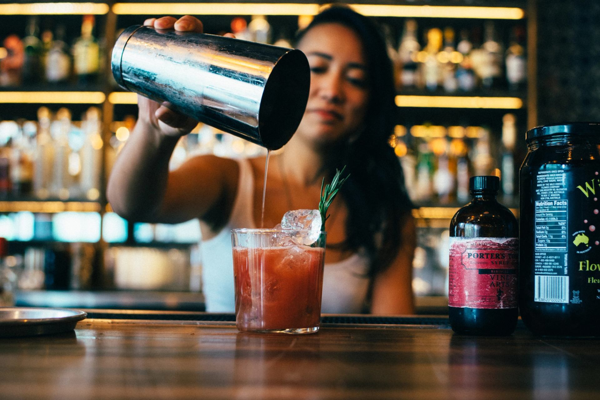 Close-up of a bartender pouring a cocktail at Native Tongues Taqueria in Calgary