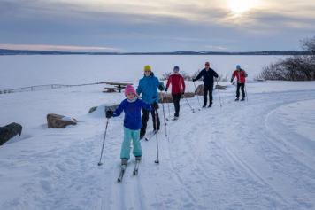 A group of cross country skiers enjoy the trails as the sun goes down at the Bonnyville Nordic Ski Club