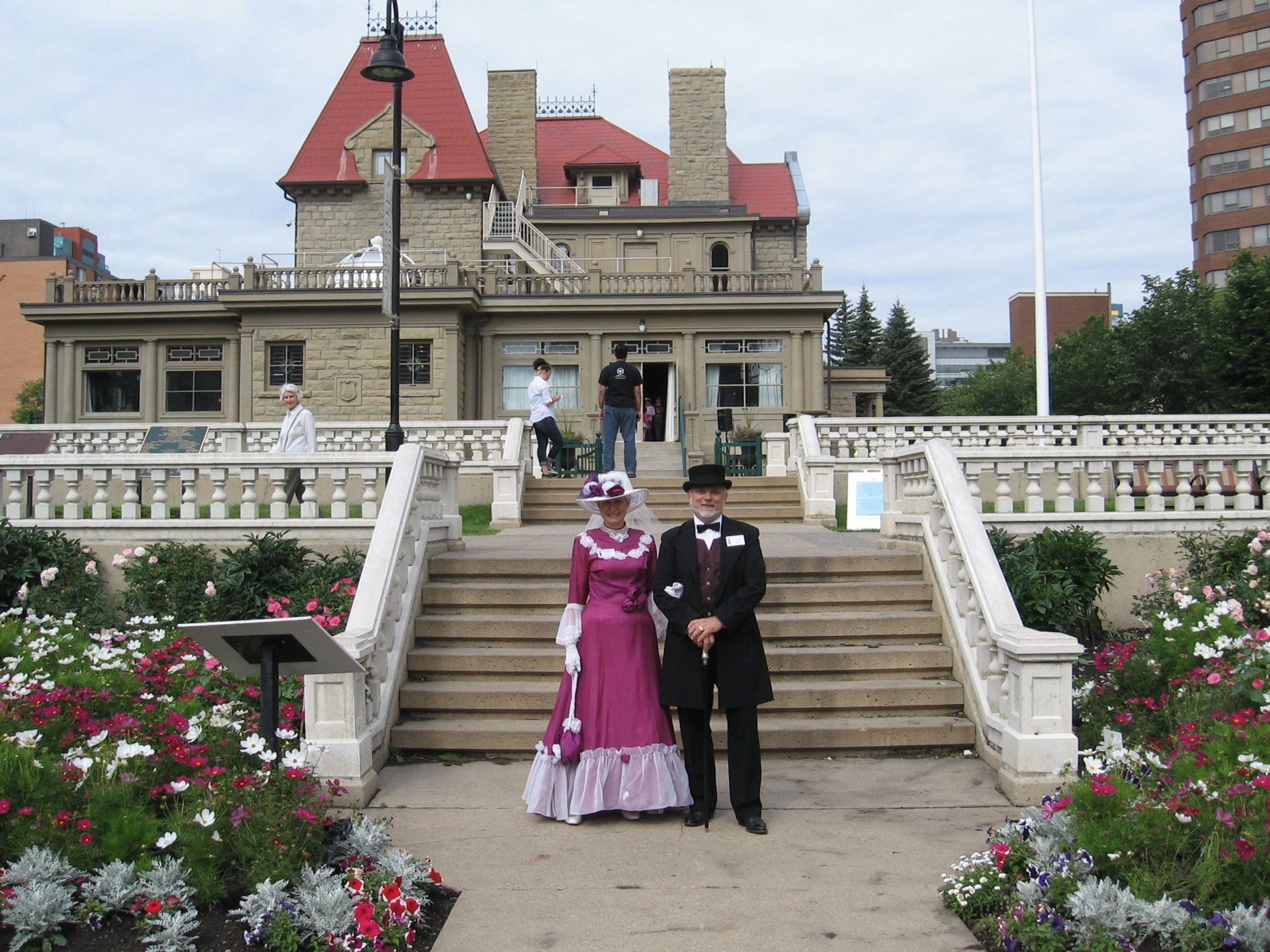 Staff in historic costumes standing in from of a historic building.