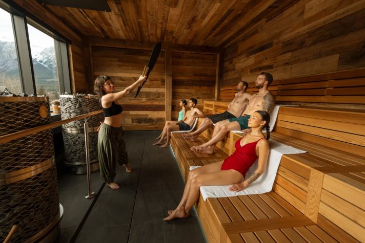 Group of people relax in a sauna at Everwild Canmore