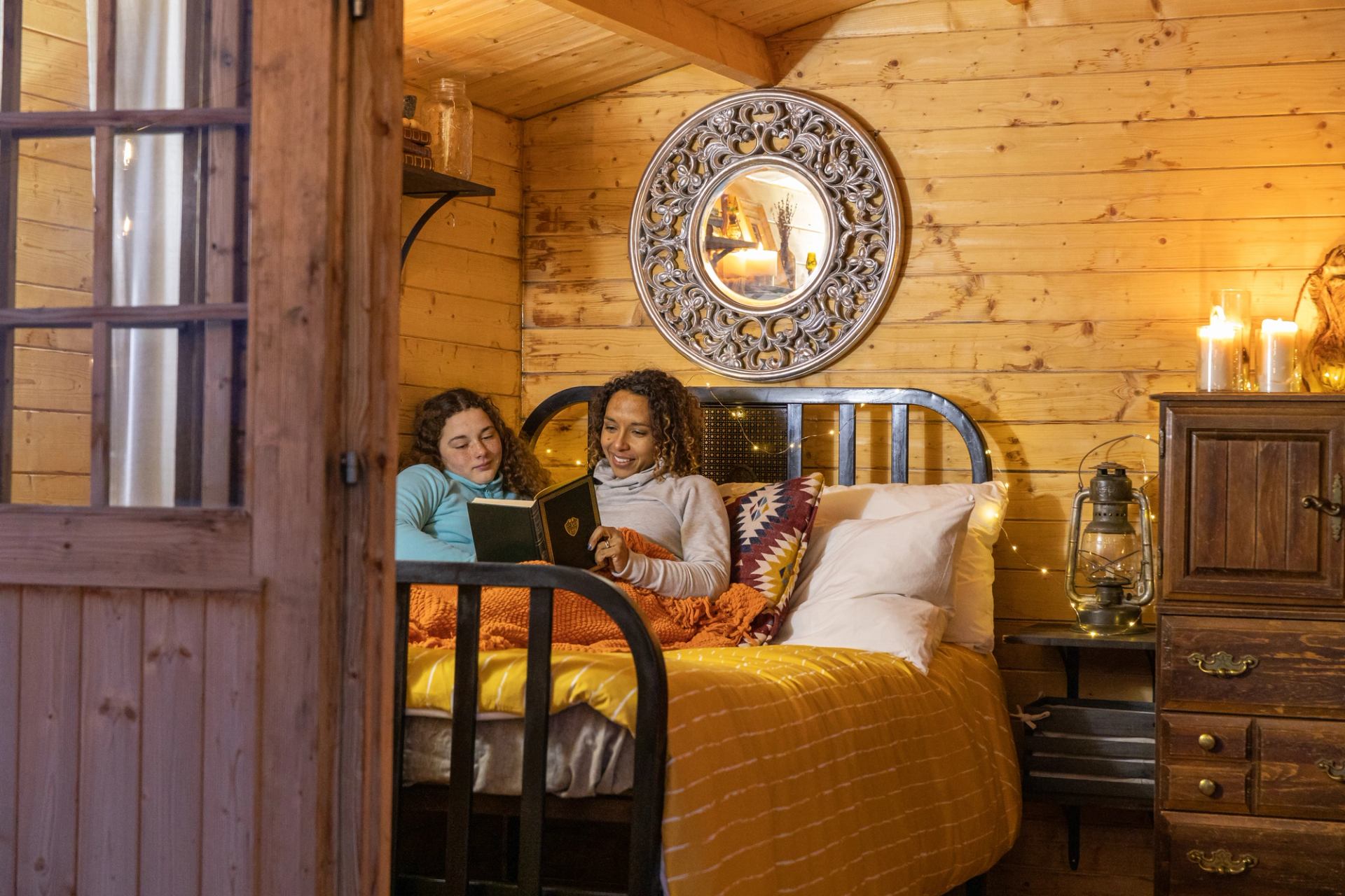 Mother and daughter reading a book in a bedroom at The Rise AirBnb