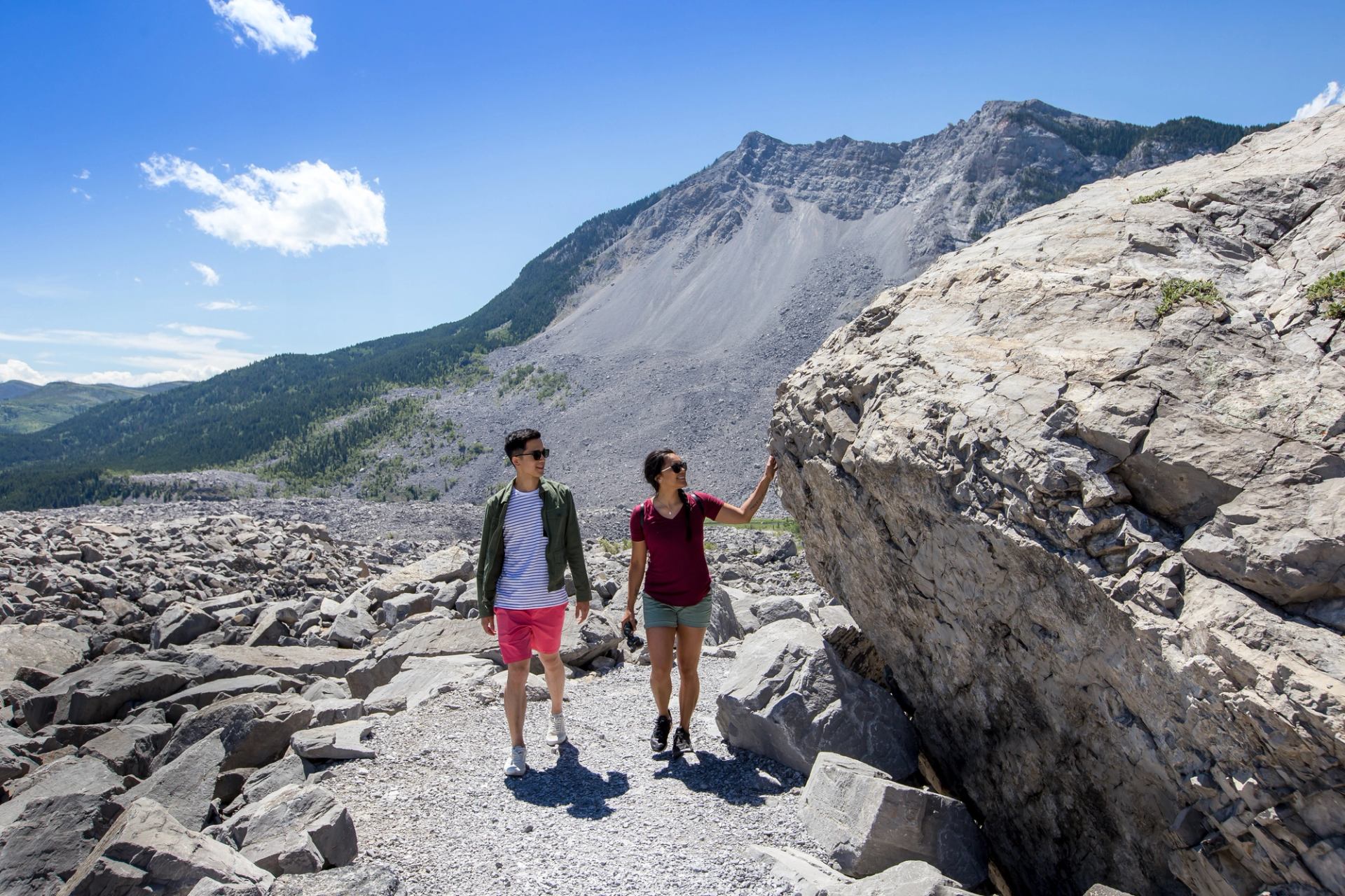 Women touching large boulder at Frank Slide.