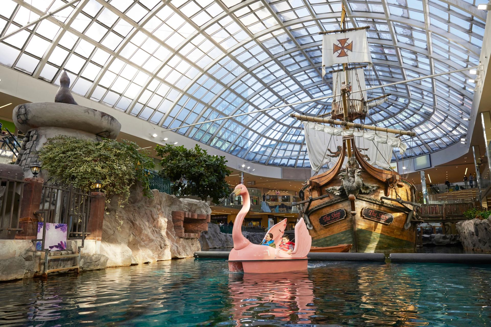 Family and kids enjoying the Birds of Paradise Swan paddle boat ride at West Edmonton Mall.