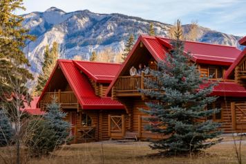People enjoying a beverage on the deck of a Miette Mountain Cabins.