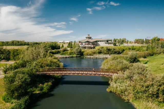 A jogger crosses a bridge over water in Muskoseepi Park in Grande Prairie.