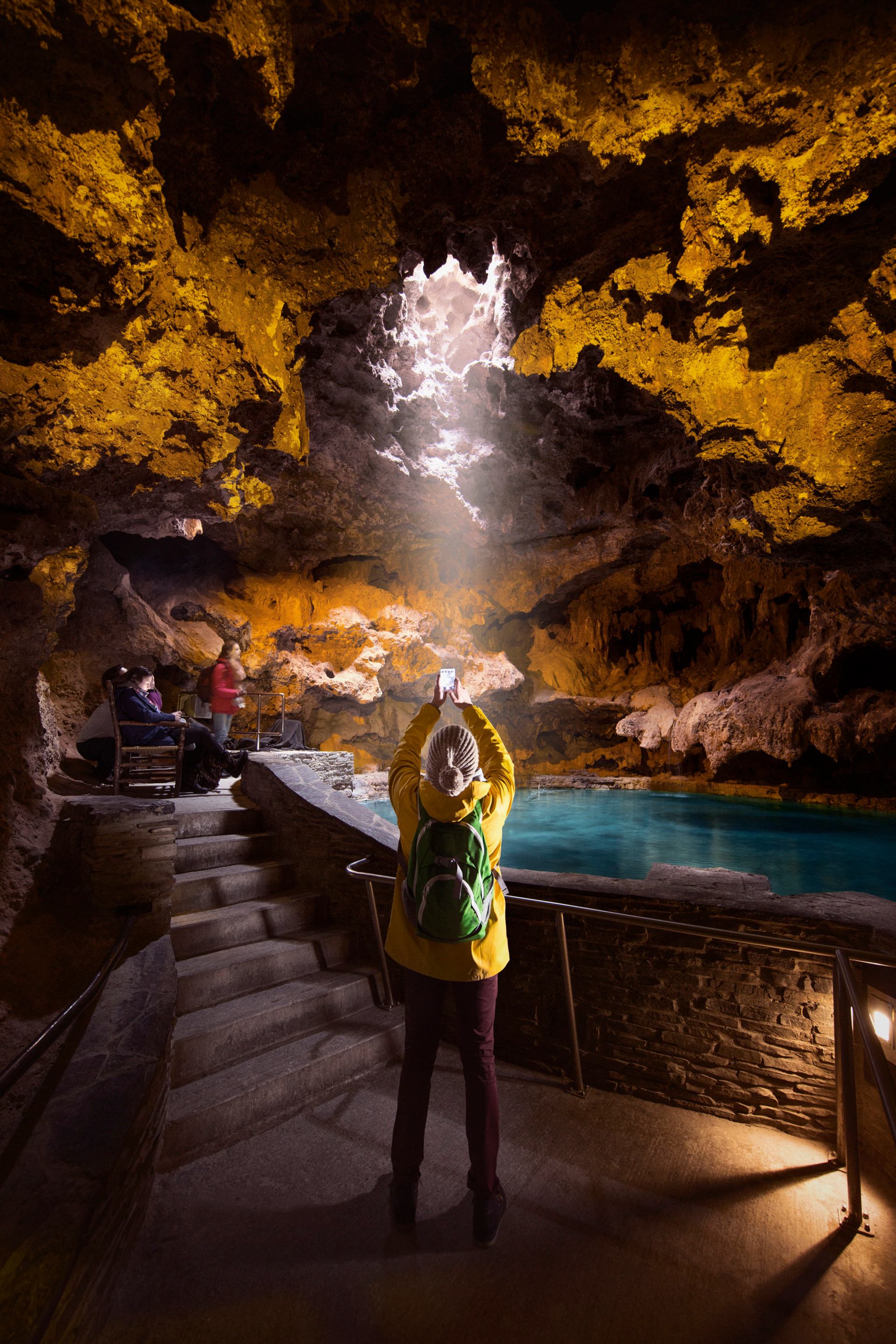 Visitor taking a photo in the cave at the Cave and Basin