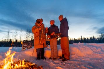 Indigenous Knowledge Keeper and Mahikan Trails owner Brenda Holder shares knowledge by the fire with young participants in the gudied walk