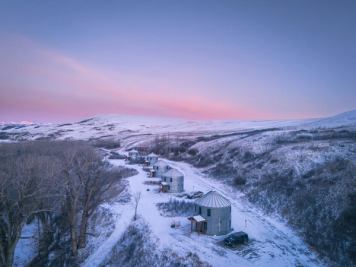 Winter sunset over silo cabins nestled in a snowy landscape.