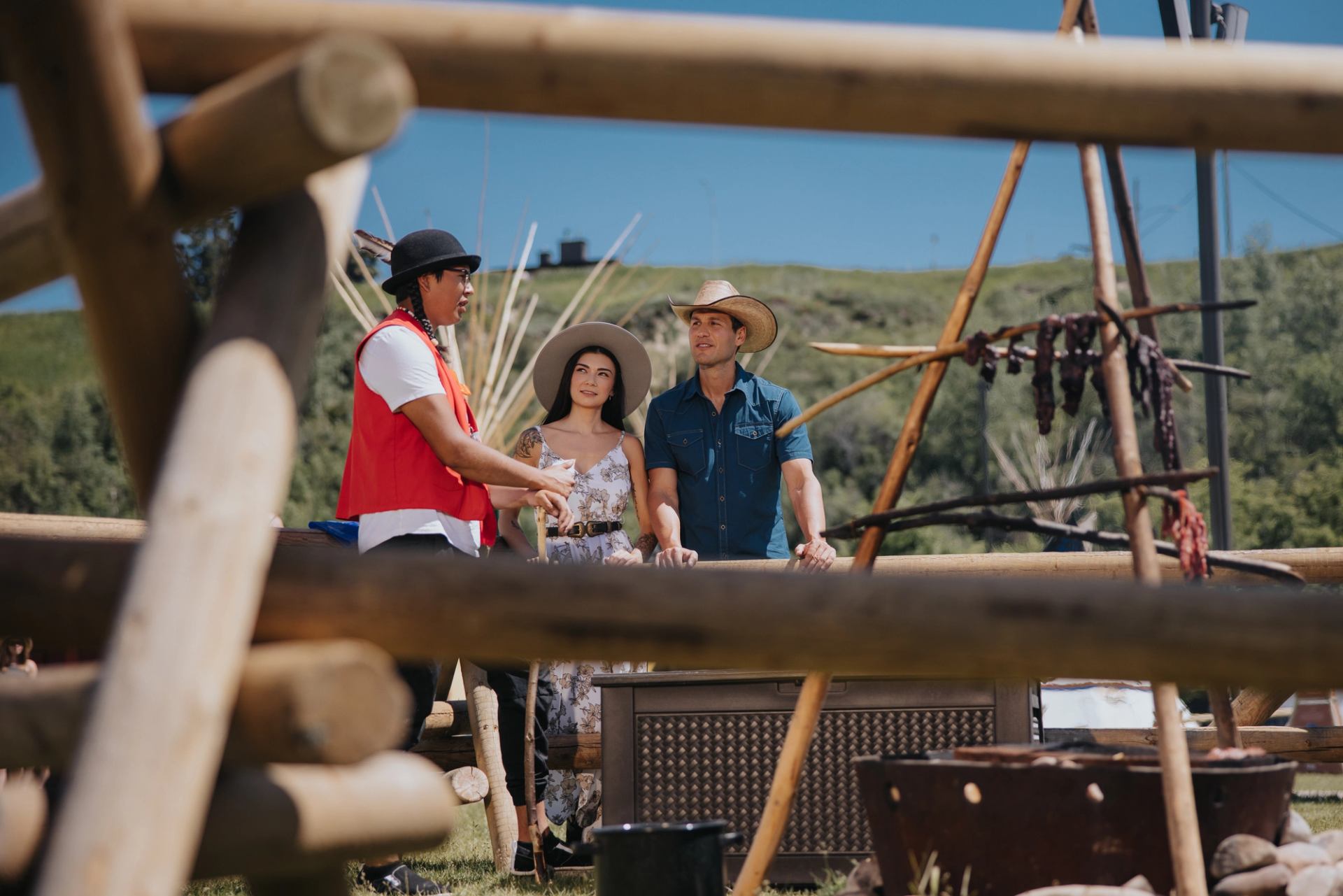 A couple listens to an Indigenous interpreter at Elbow River Camp in Calgary.