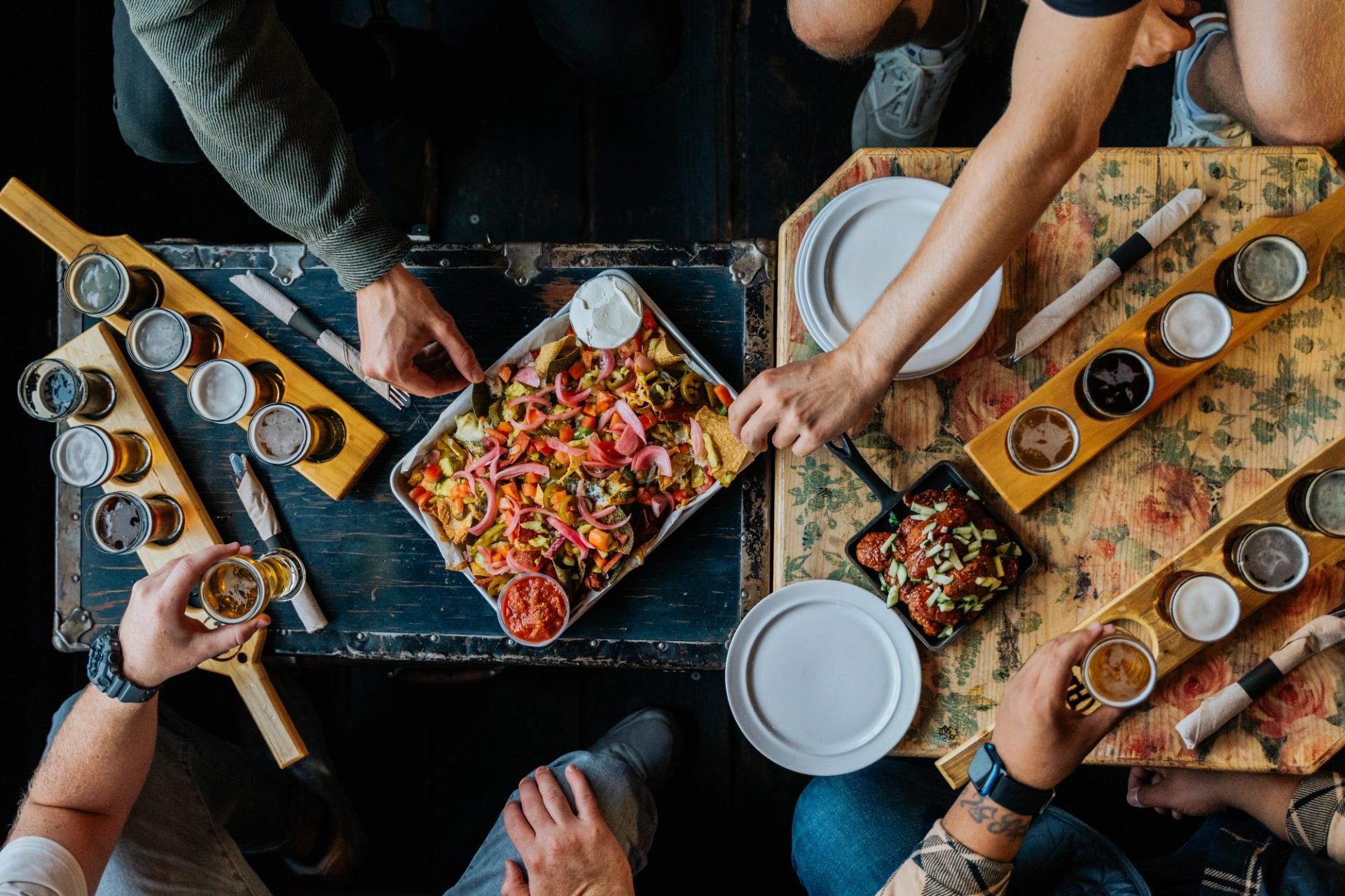 Overhead view of people with nachos and beer flights at Half Hitch Brewing Company in Cochrane.