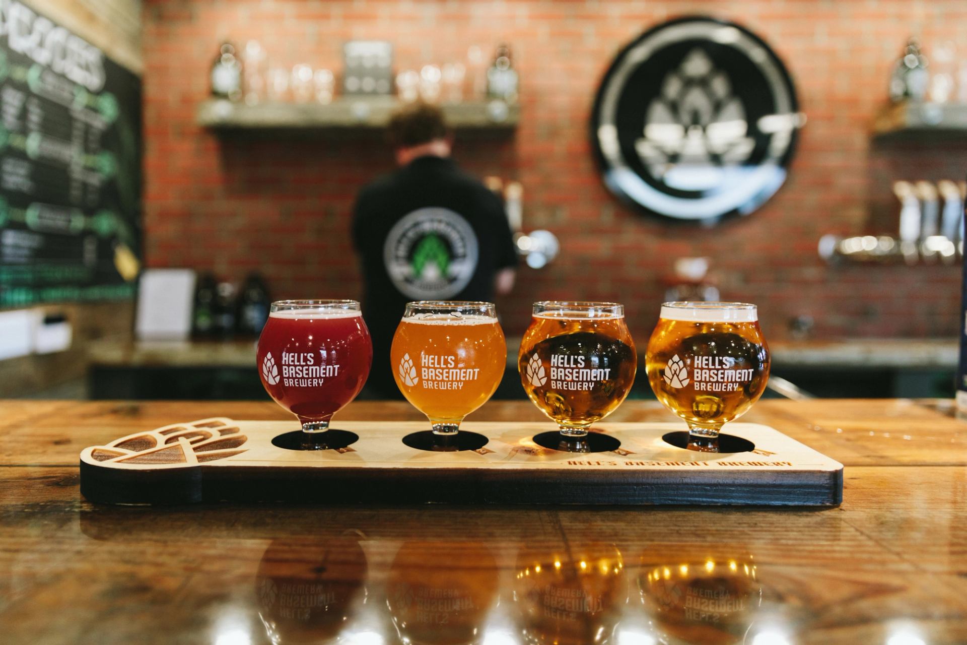 A beer flight with four samples of delicious beers displayed attractively on a wooden plank