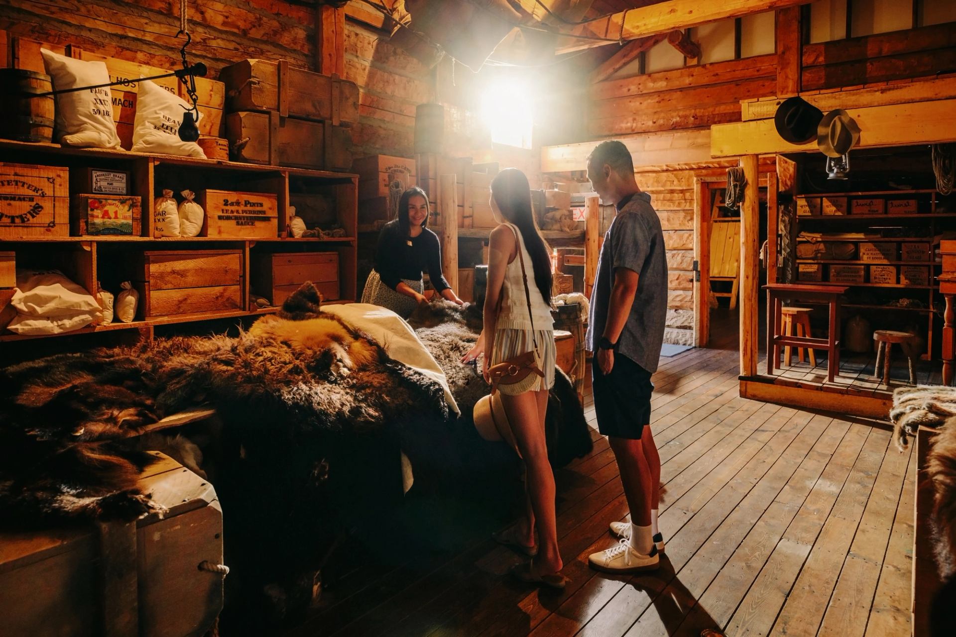 People on a guided tour at Fort Whoop-Up, inside of a old fort store.