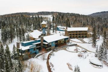 View from above a hotel surrounded by forest in the winter.