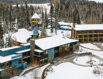 View from above a hotel surrounded by forest in the winter.