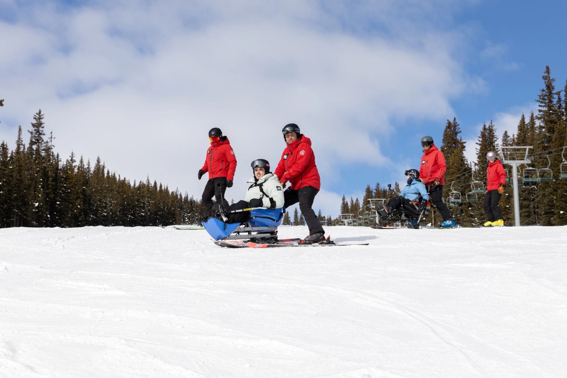 A wheelchair skiier is assisted by guides at Marmot Basin Ski Resort.