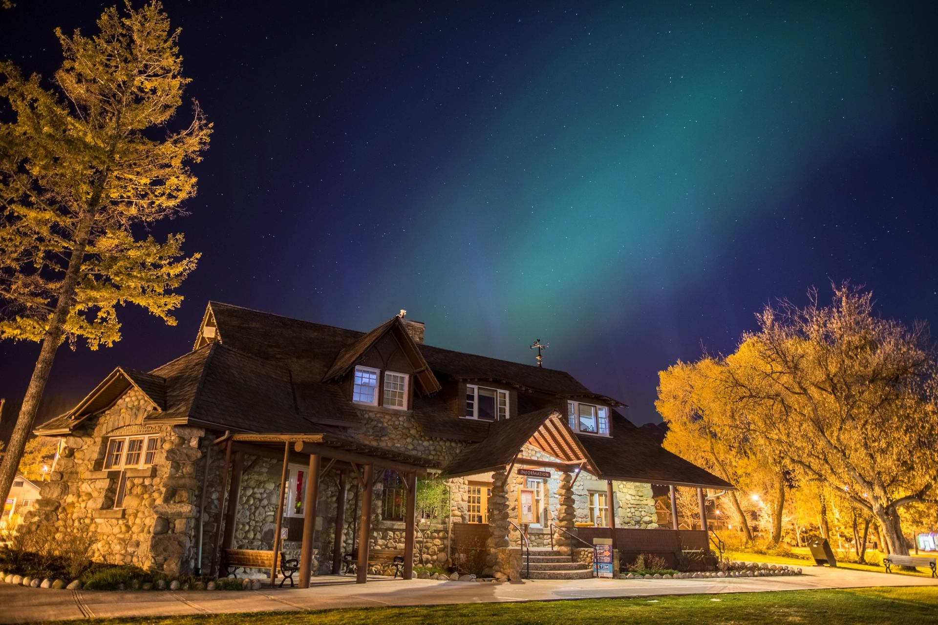 The Jasper National Park Visitor Information Centre building at night under the northern lights