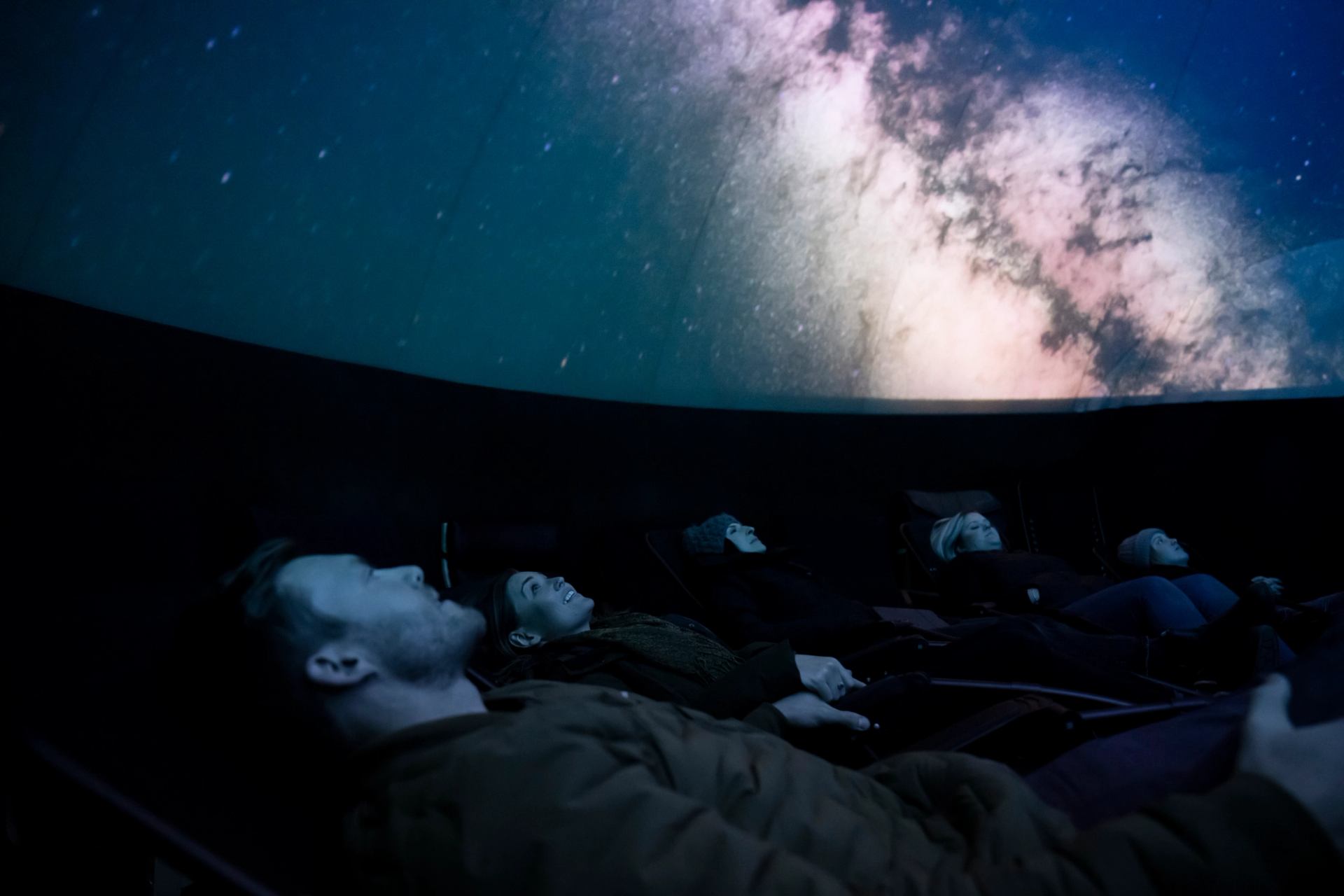 A young couple viewing dark sky projections in the planetarium at Jasper Park Lodge.