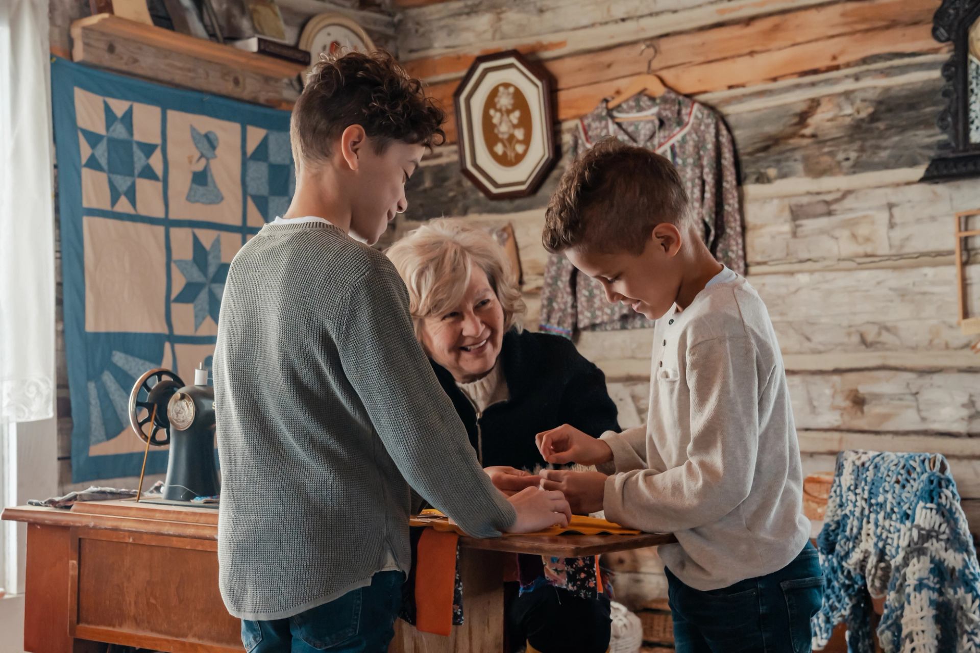 Indigenous woman showing kids how to sew and make crafts at Métis Crossing