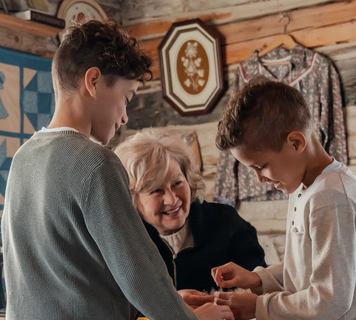 Indigenous woman showing kids how to sew and make crafts at Métis Crossing