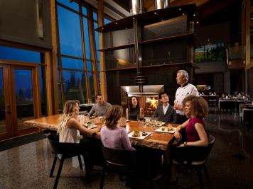 Friends having dinner and chatting with the Chef at Azuridge Estate Hotel in Priddis