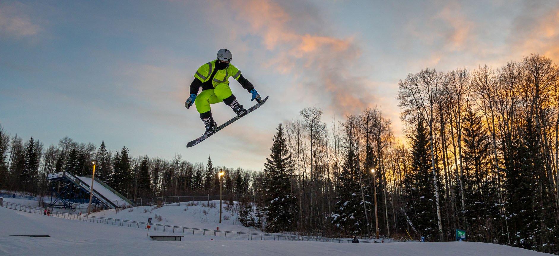 A snowboarder hits a jump at Nitehawk Adventure park.