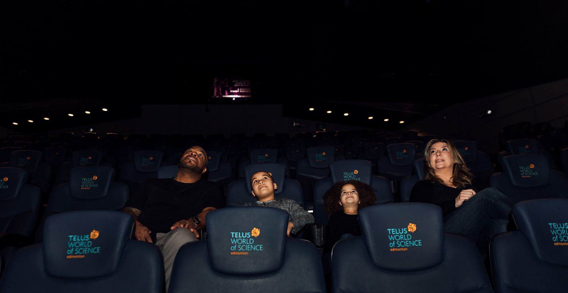 A family watches a movie at the science centre's IMAX theatre.