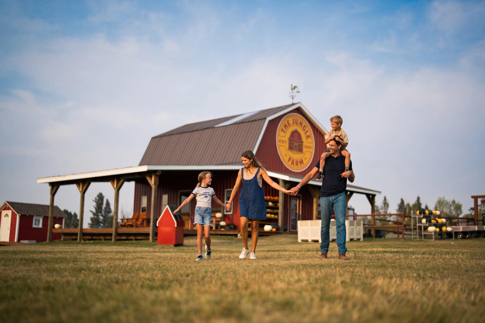 A happy family walk with The Jungle Farm barn in background.