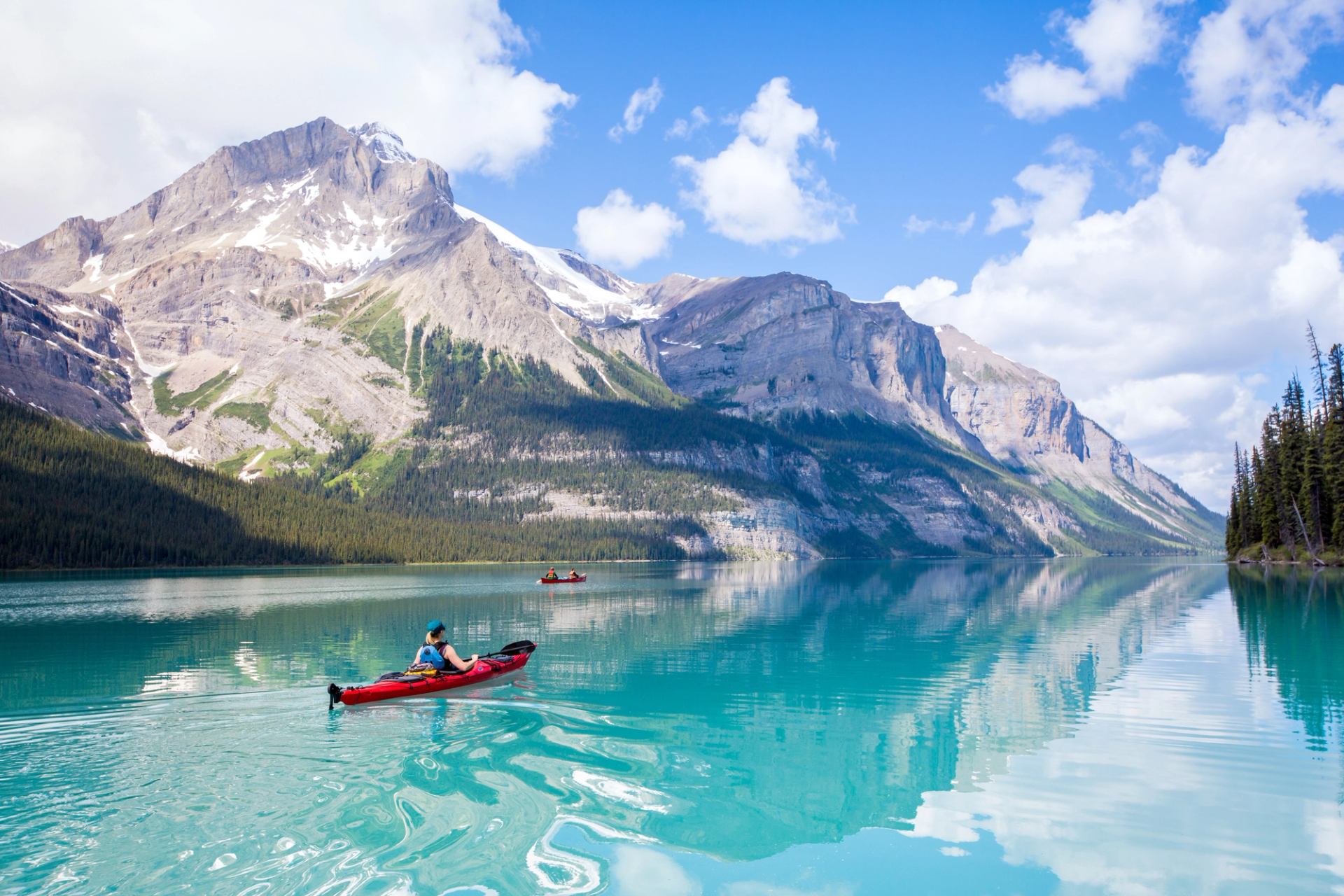 Scenic shot of people canoeing and kayaking on Maligne Lake