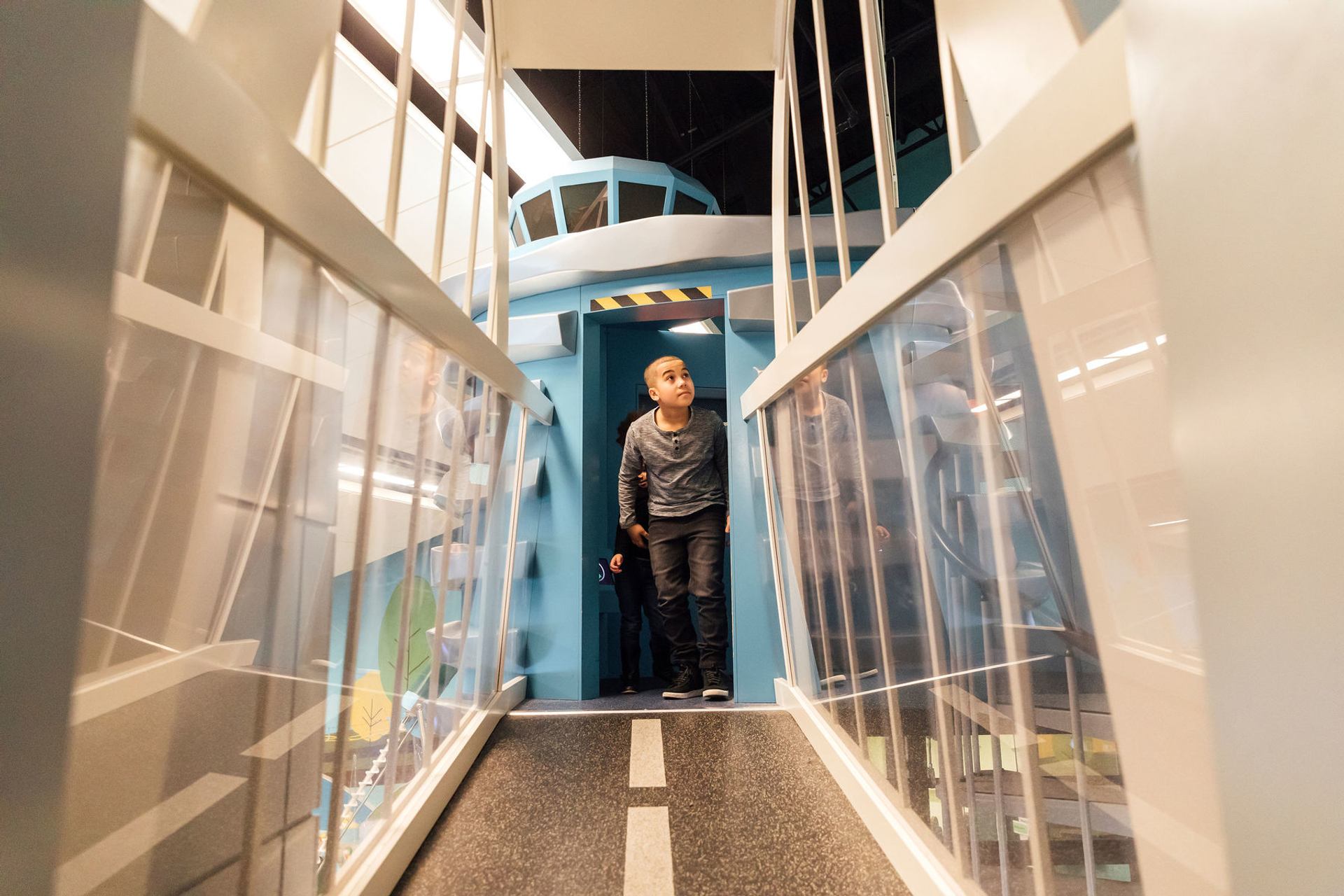 A boy enters a “treehouse” hallway in CuriousCITY to see some Edmonton landmarks.