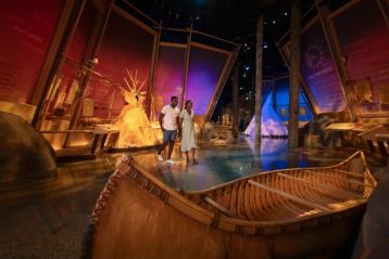 Two people explore the Indigenous Peoples Experience at Fort Edmonton Park.