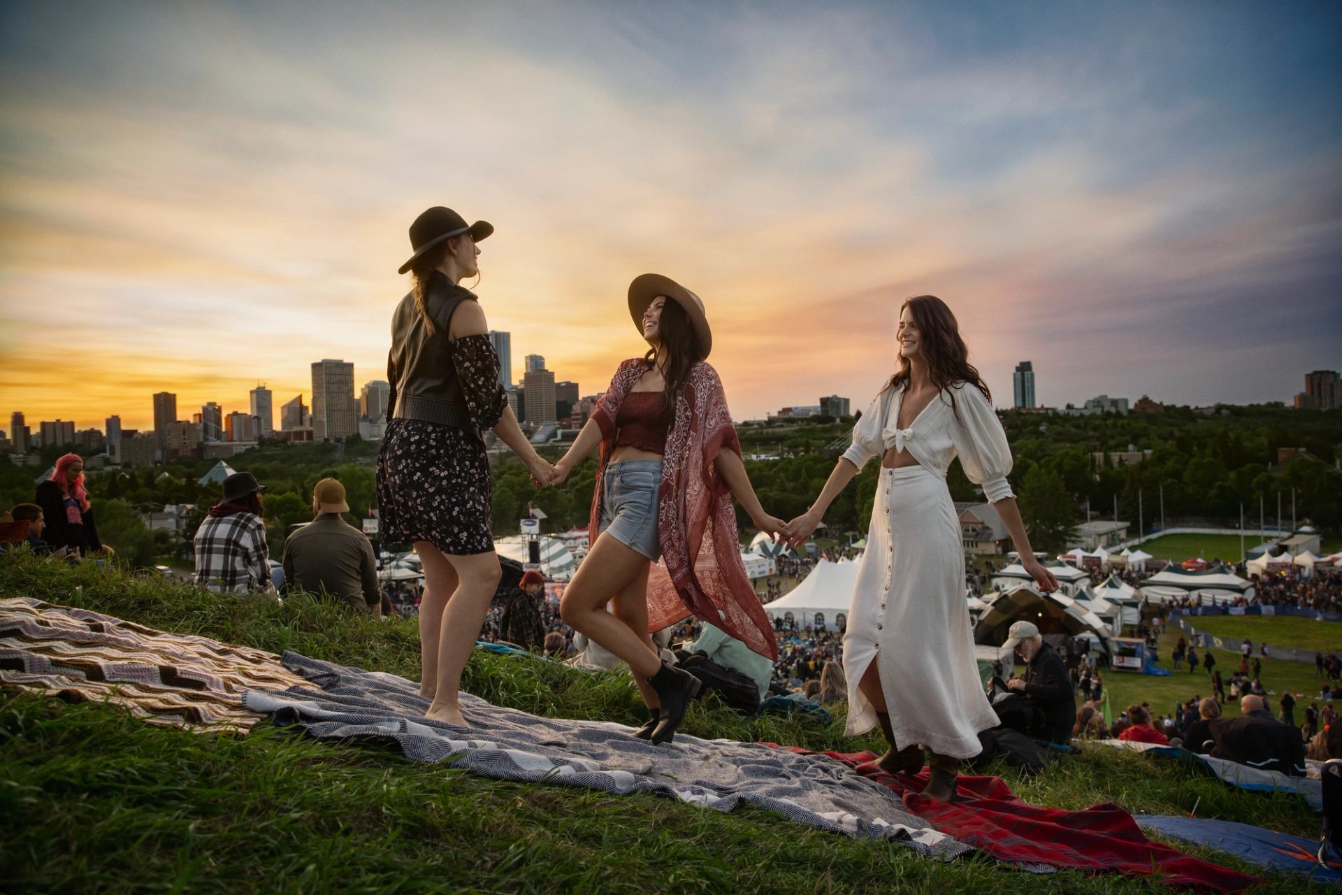 Friends enjoying the Edmonton Folk Music Festival with downtown Edmonton in the background.