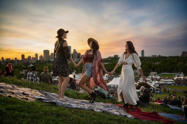 Friends enjoying the Edmonton Folk Music Festival with downtown Edmonton in the background.