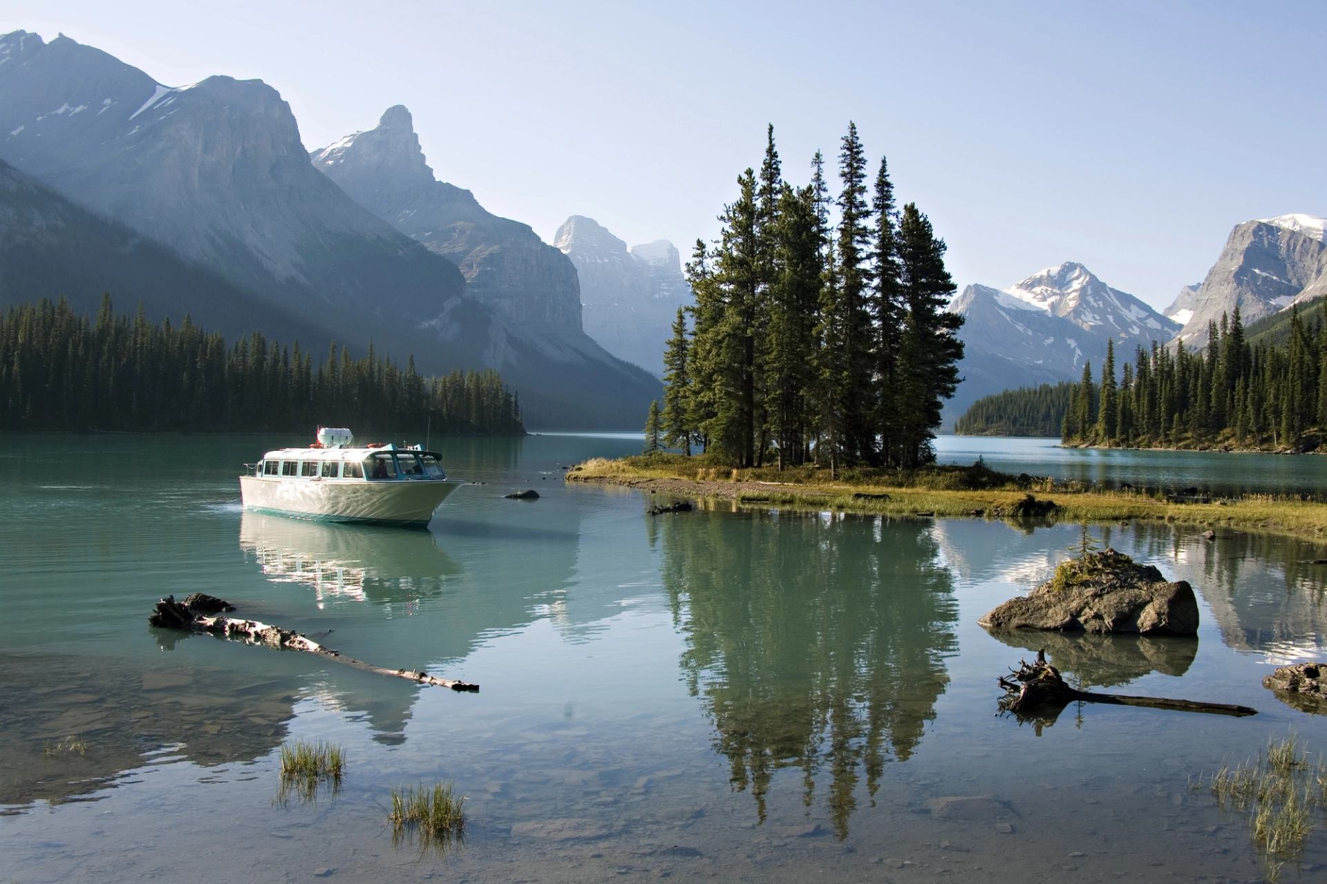 A cruise boat on Maligne Lake near small Spirit Island with the Rockies in the background.