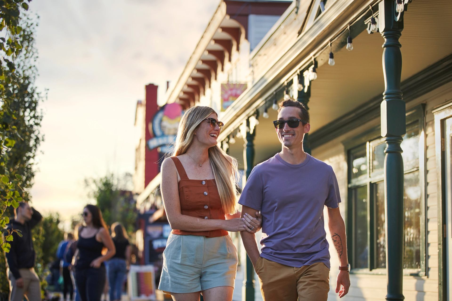 Couple arm in arm walking down Historic Downtown Cochrane