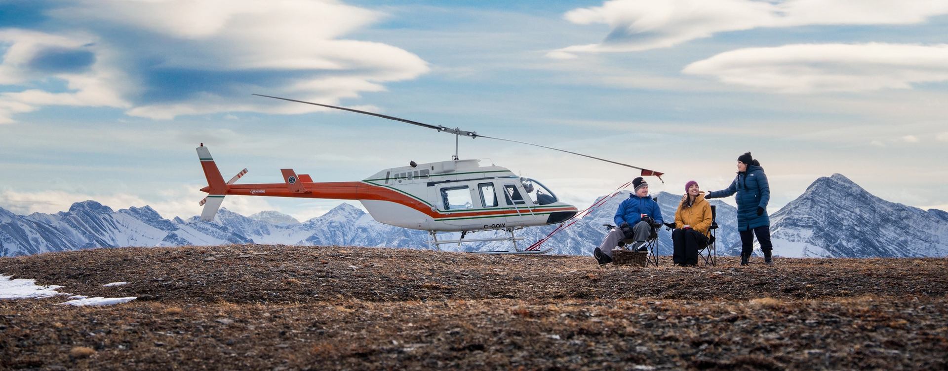 Helicopter on mountain top with guests.