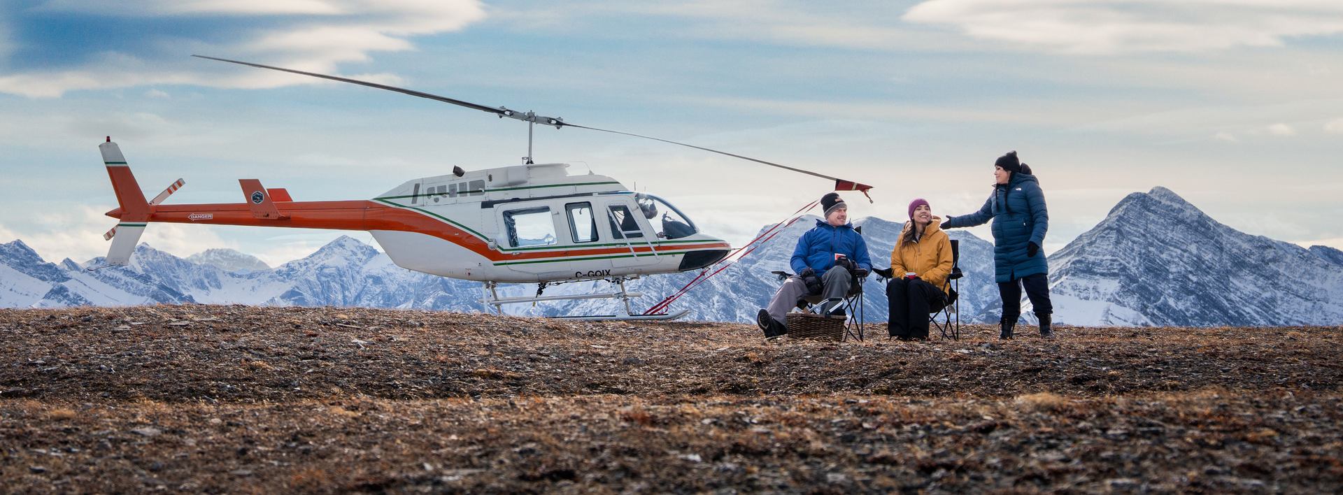 Helicopter on mountain top with guests.