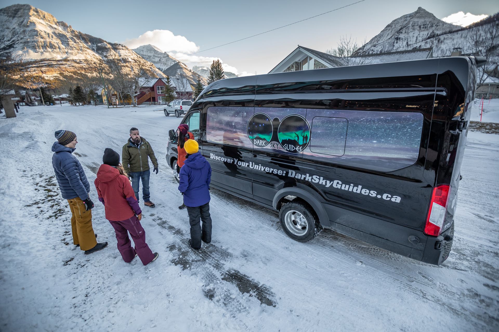 Tour guides standing in front of the Dark Sky Guides van in Waterton.