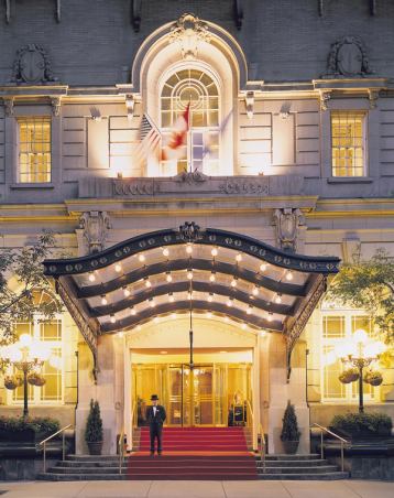 Front entrance of a luxury hotel lit at night.